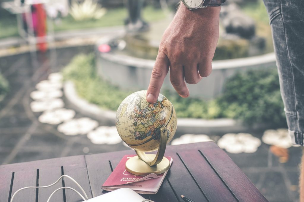 Passaporte e dedo apontando para globo, demonstrando o quanto Wise é global