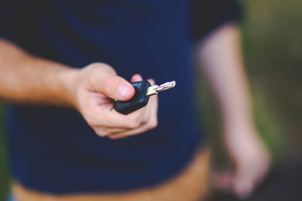 Homem segurando chave de carro, representando o uso do crédito pessoal Creditas para compra de veículo