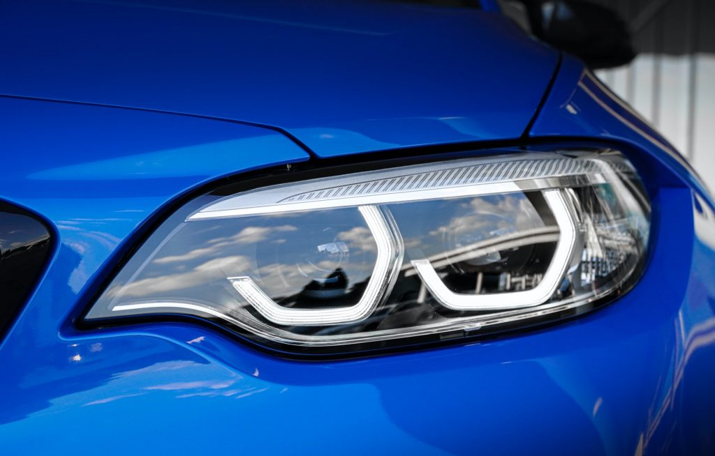 Farol dianteiro de uma BMW azul, um exemplo de carro o qual é possível comprar e vender na Muuv
