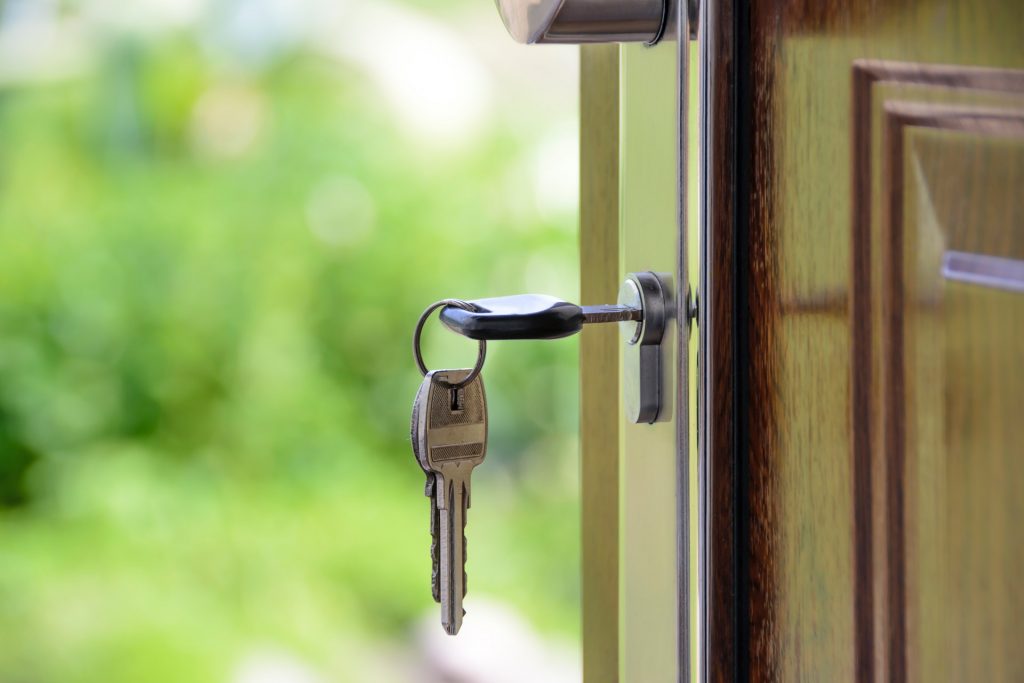 Porta aberta de uma casa, com chaves penduradas, simbolizando portas abertas para Crédito de alto valor como fazer empréstimo para veículo e imóvel, por exemplo