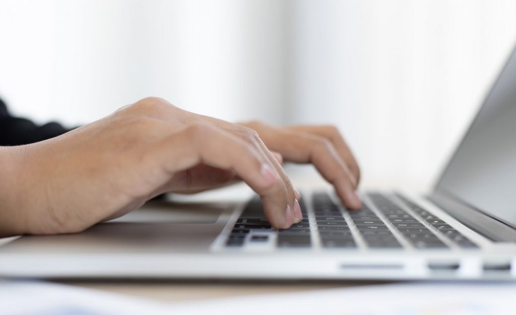Mãos digitando em teclado de notebook, simbolizando como solicitar crédito CrediJet