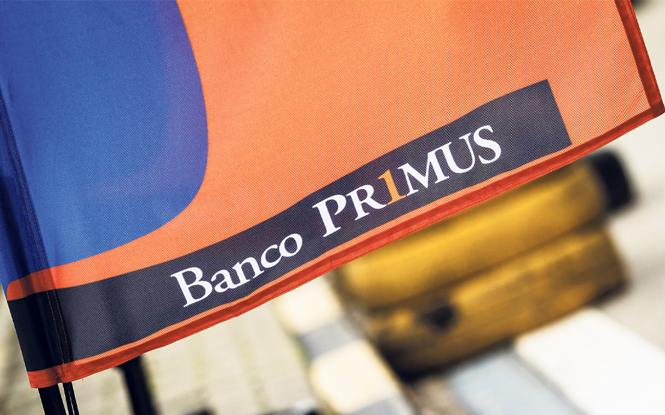 nome e logo do banco primus em fundo laranja e azul