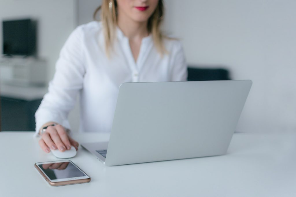 imagem com uma mulher com um computador acessando o site do Portal das Finanças