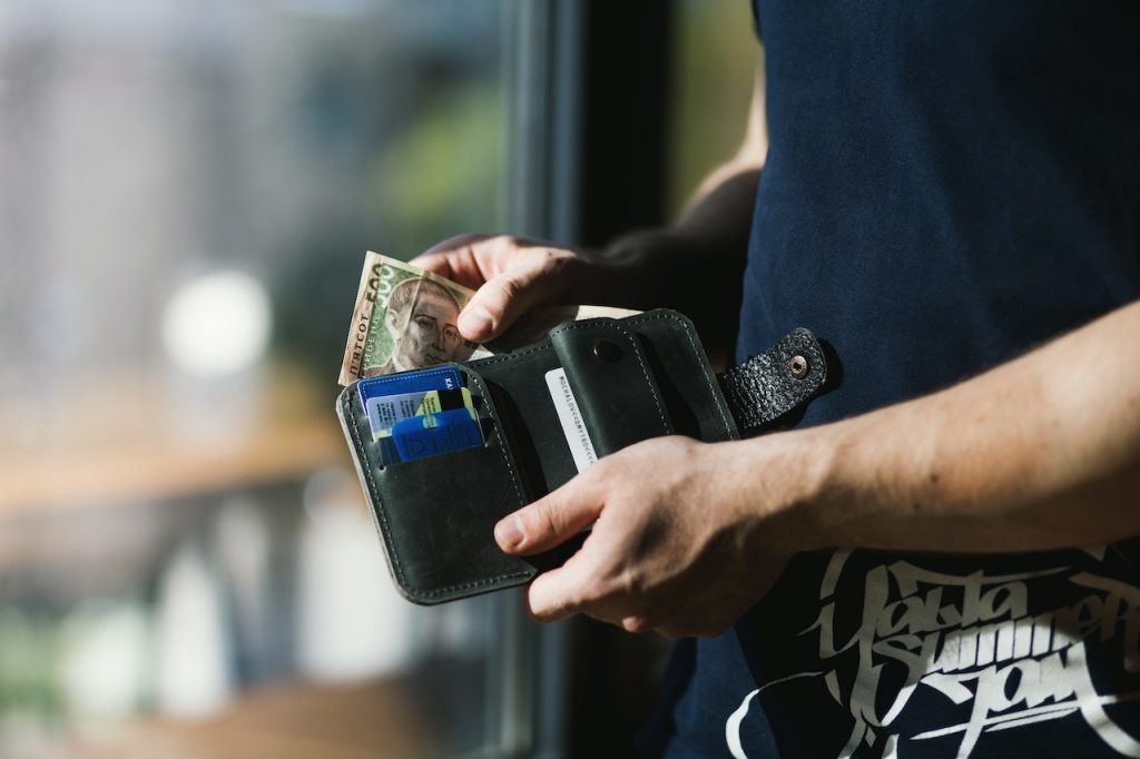 imagem com uma pessoa segurando uma carteira com vários cartões de crédito