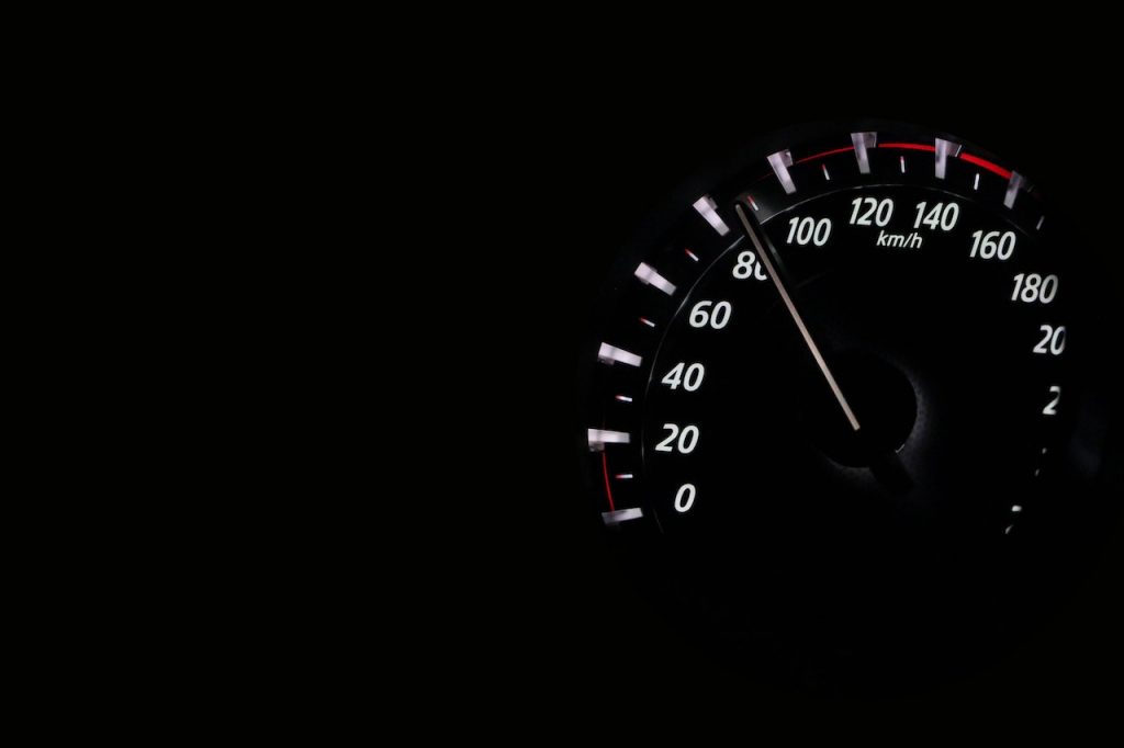 imagem com o fundo preto com um marcador de velocidade de um automóvel