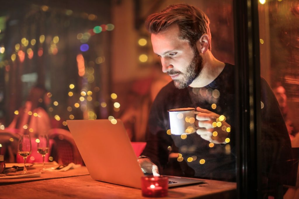 imagem com um homem em frente a um computador pesquisando sobre como obter a bonificação no spread do crédito