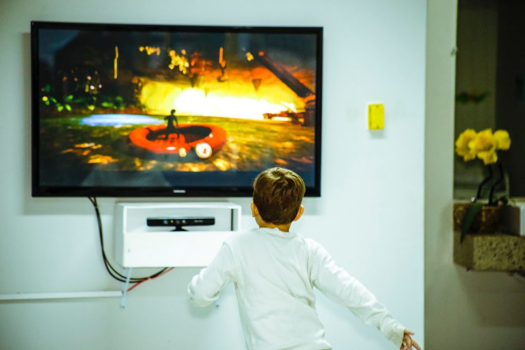 imagem com uma criança vendo televisão após conhecer os pacotes MEO