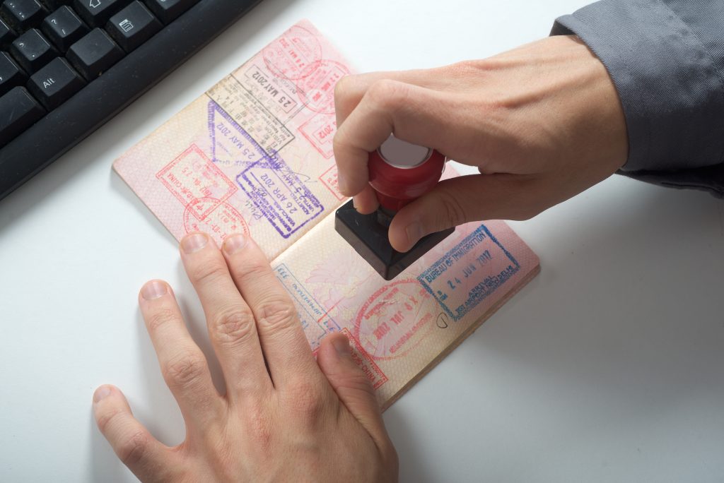 Mãos carimbando um passaporte