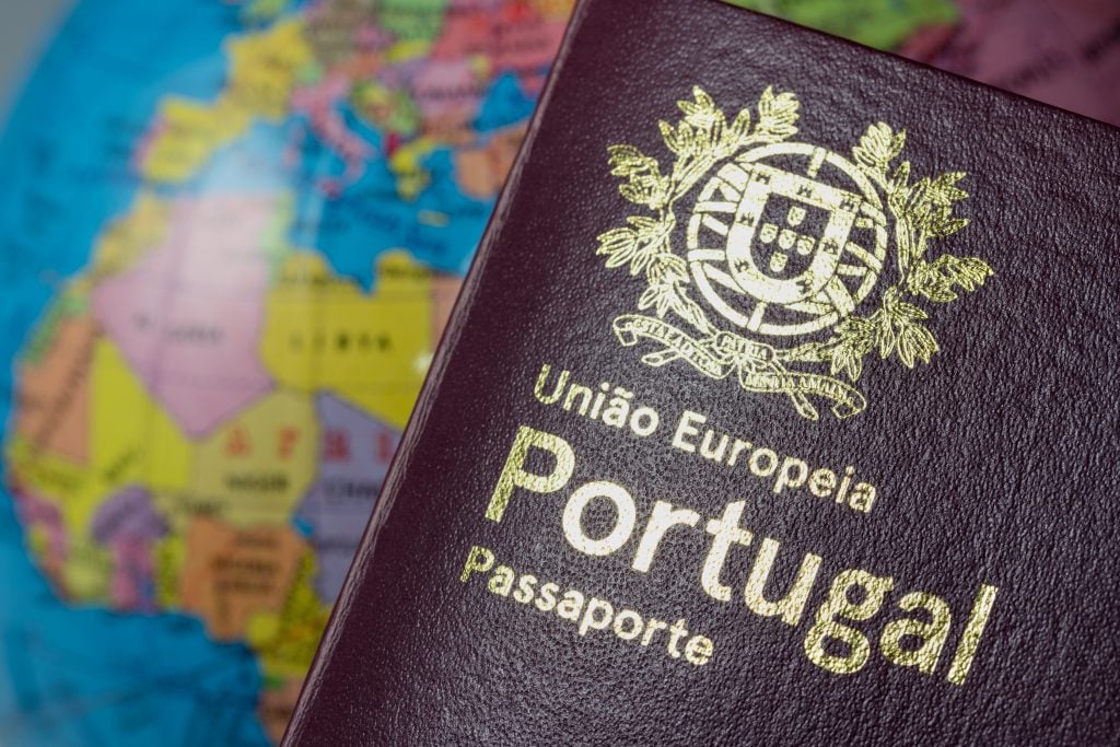 Passaporte português com mapa mundi ao fundo