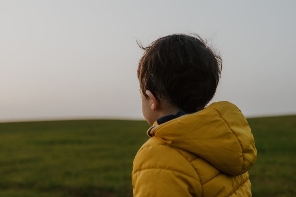 Criança de casaco olhando o horizonte