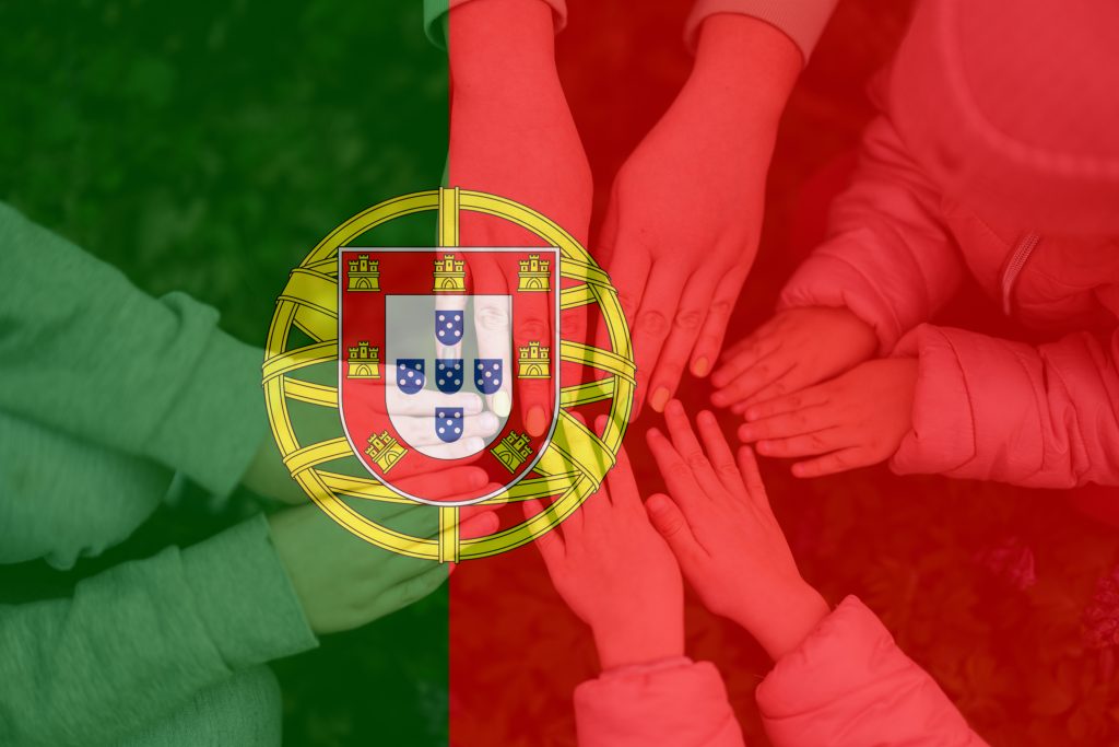 Mãos de adultos e crianças unidas com bandeira de portugal