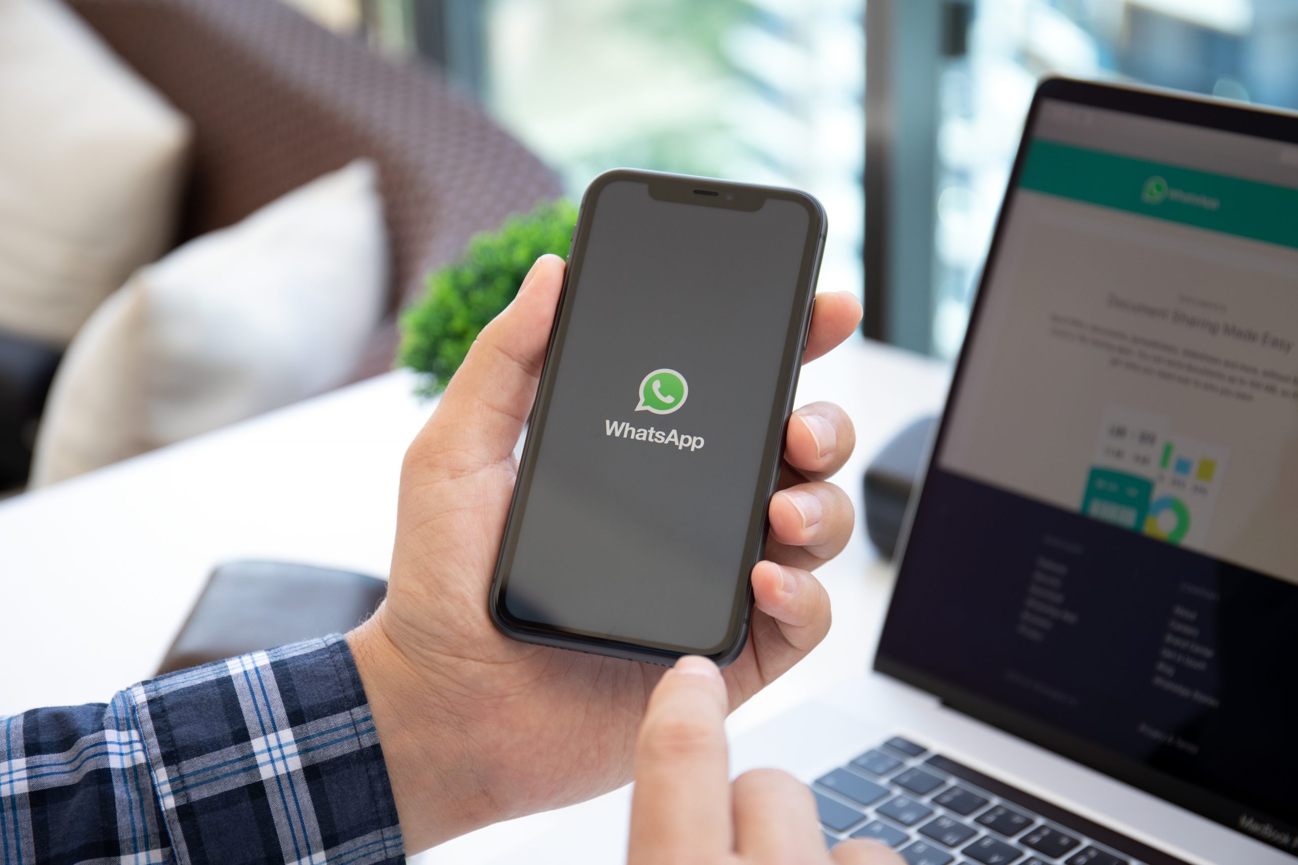 Pessoa segurando celular com logo do Whatsapp