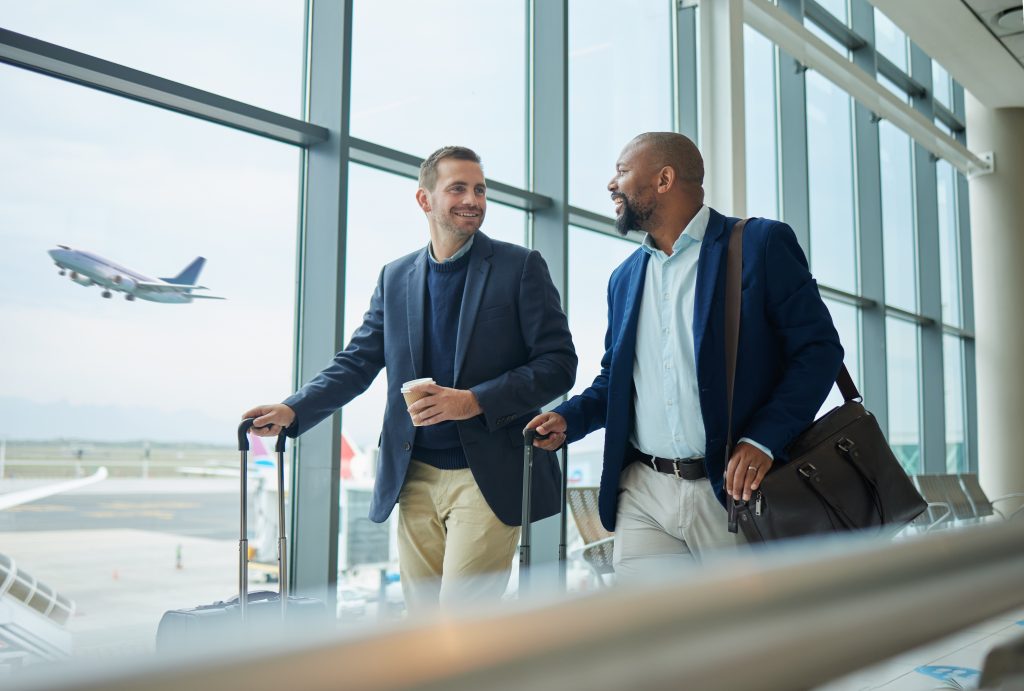 Dois homens de negócios conversando e caminhando para embarque em aeroporto