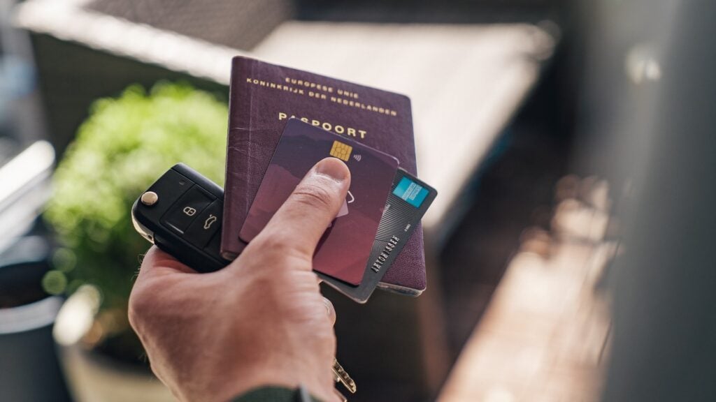 pessoa com passaporte na mão e um cartão de crédito 