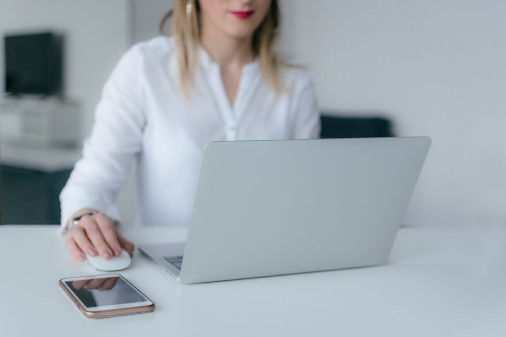 imagem com uma mulher com um computador acessando o site do Portal das Finanças
