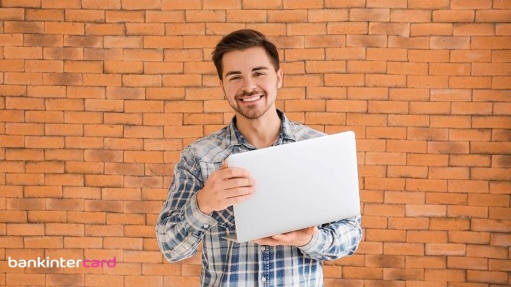 Homem sorrindo e segurando notebook